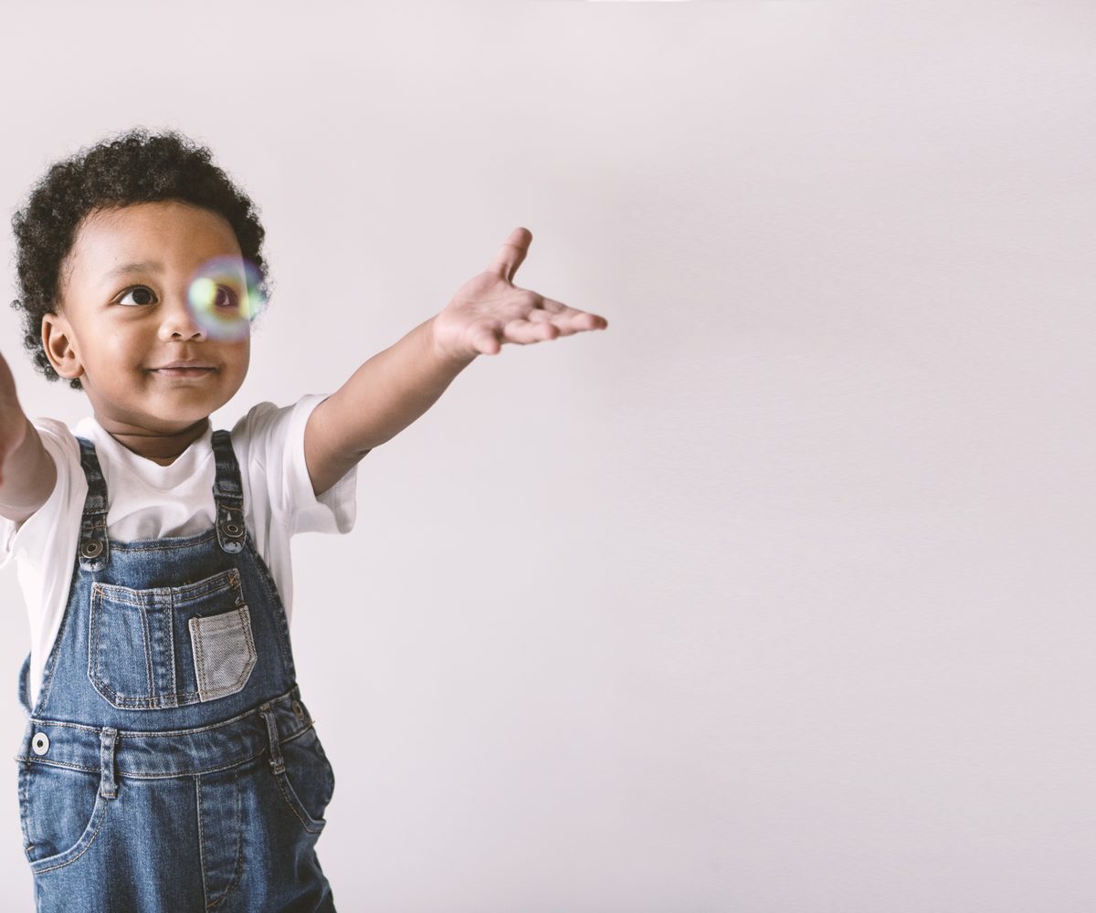 A smiling child with open arms