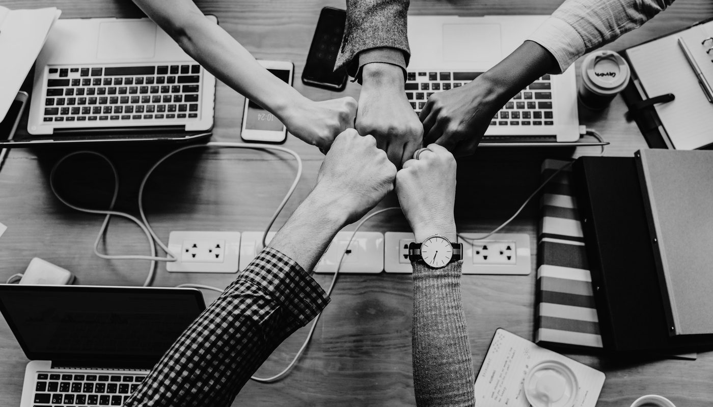 A team joining hands over a work table